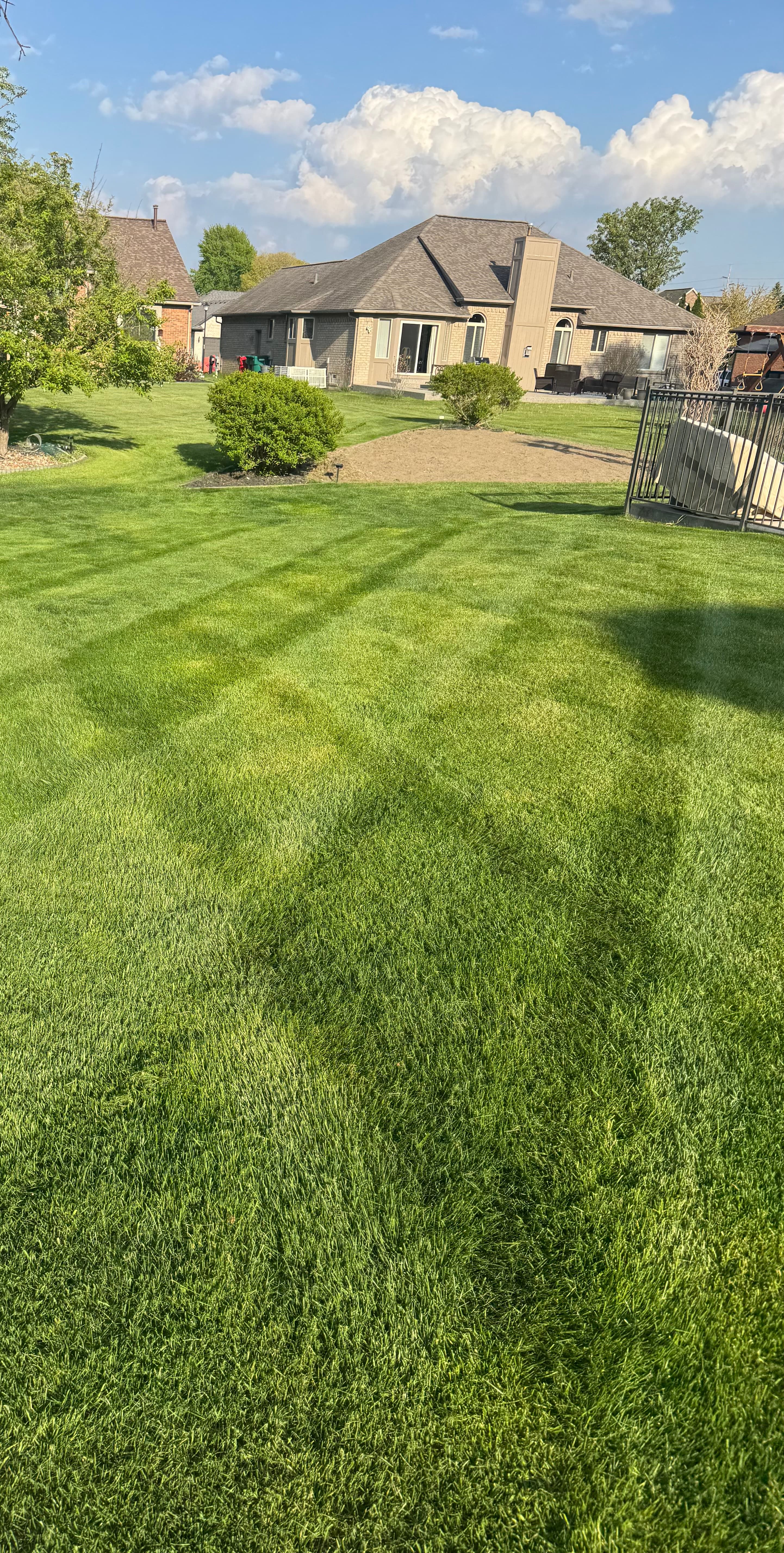 Backyard lawn mowing with stripe pattern and iron fence โ Washington Township Michigan