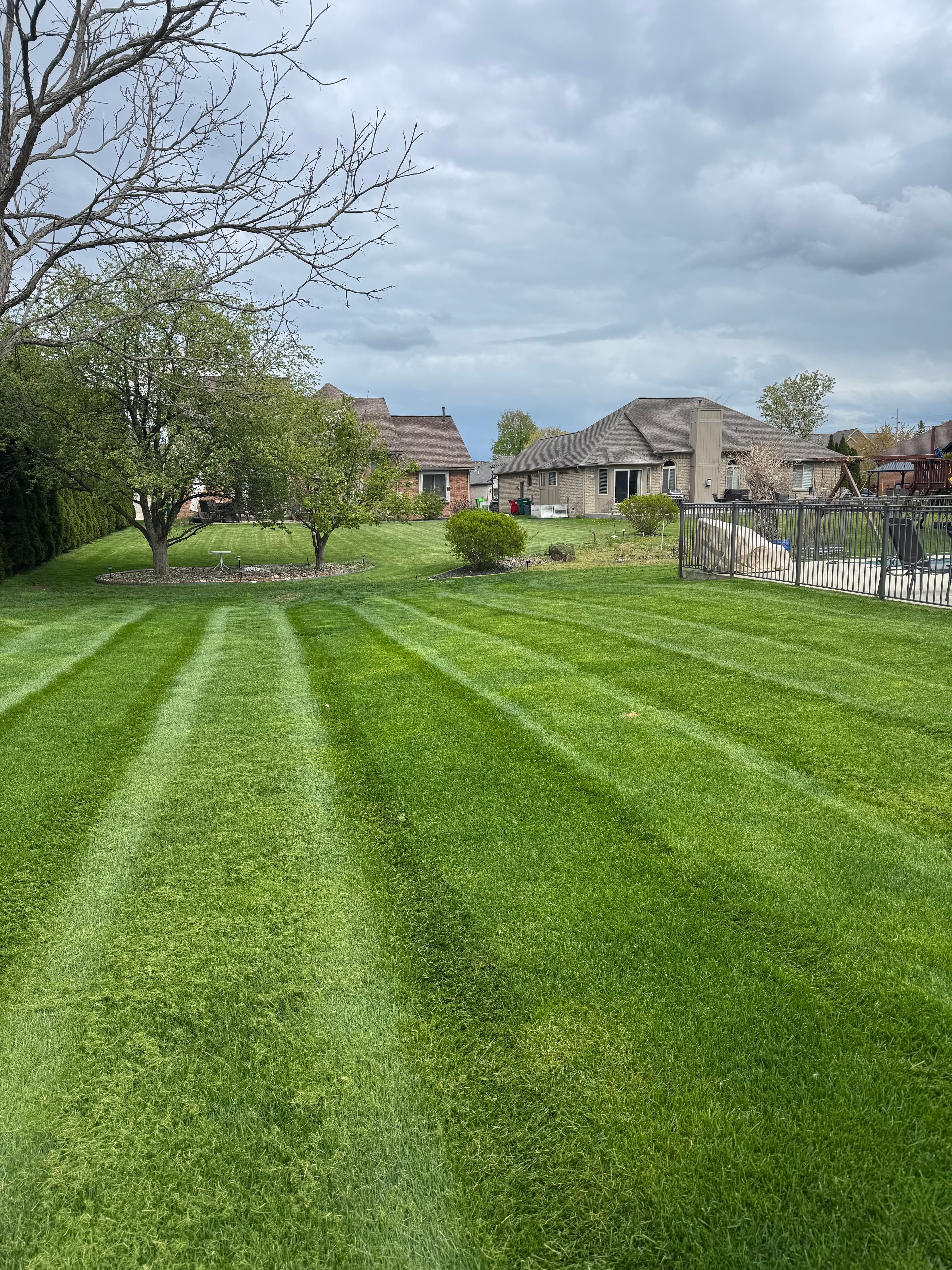 Precision lawn mowing service on large residential property in Macomb County Michigan